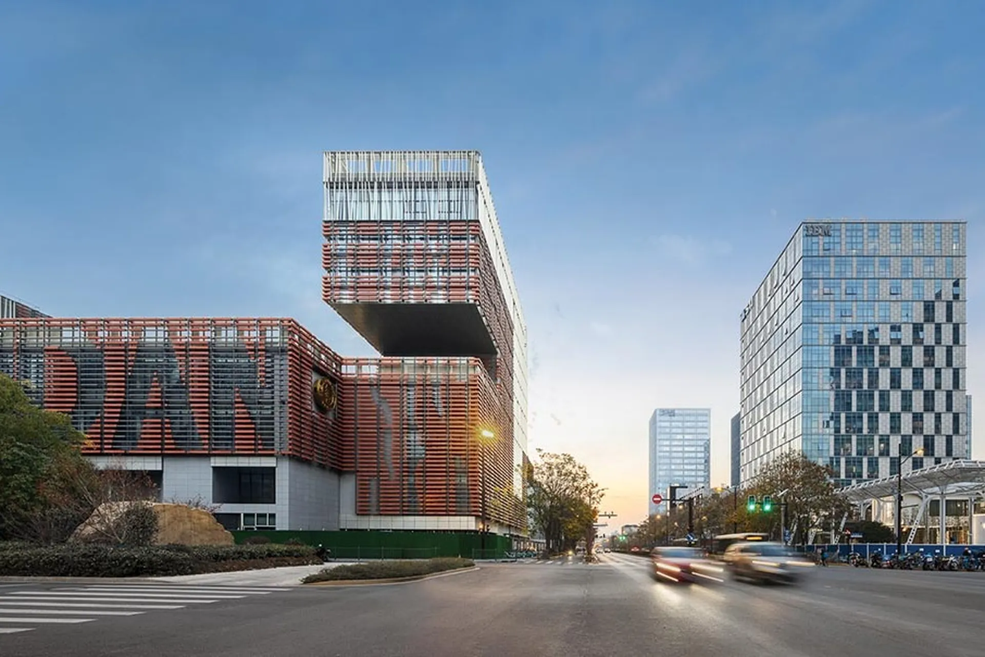 Panoramic view of Fudan University's main campus with a central lawn, surrounded by modern academic buildings.